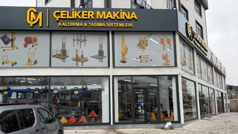 Front of the Çeliker Makina lifting and handling equipment shop in Orhanlı, Tuzla, with electric chain hoists and pallet trucks in the windows